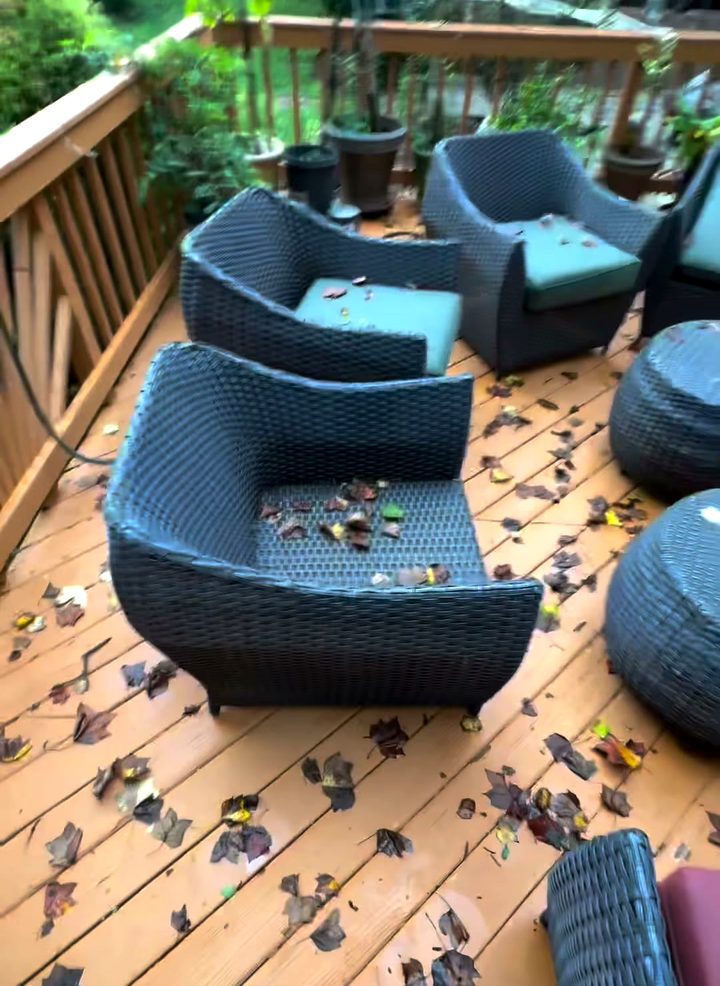 A wicker patio set with its cushions pulled off, sitting on a back deck waiting to be taken away.